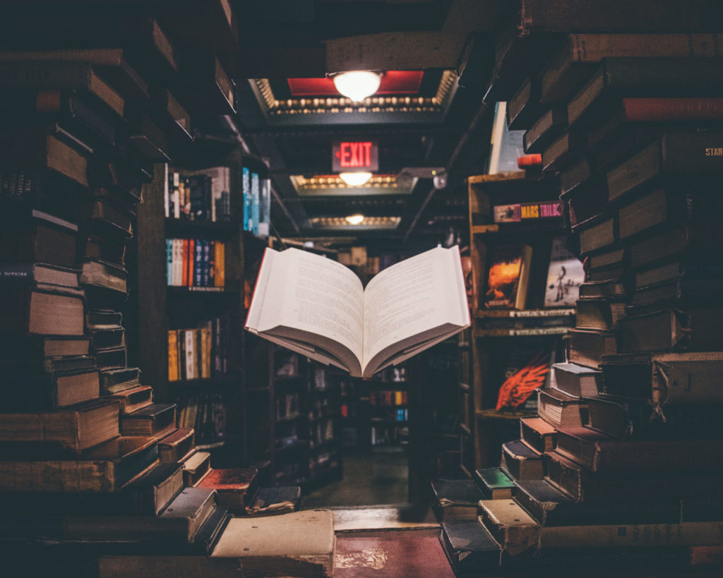 Photo of a book seeming to float between shelves.